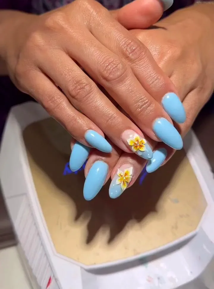 Sky blue almond nails with a hand-painted yellow flower